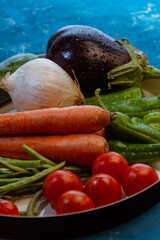 still life con Verduras frescas del huerto sobre mesa de madera con cebollas, zapallitos. tomates, berenjena, habas y pimiento verde.