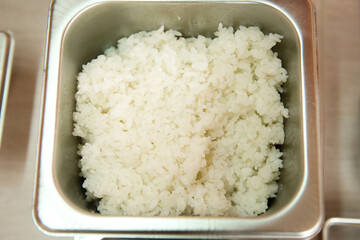 A portion of cooked rice in a metal container, top view.