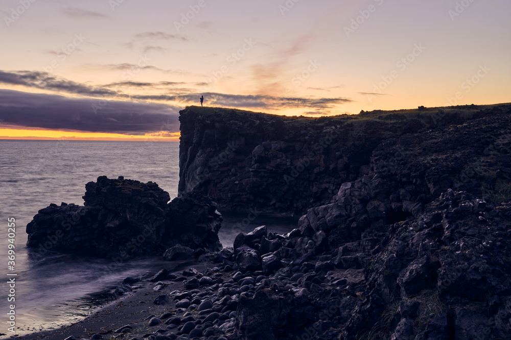 Wall mural iconic view of man on top of the hill at a sunset on the west coast of iceland