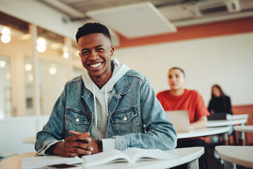Portrait of smiling boy in university classroom