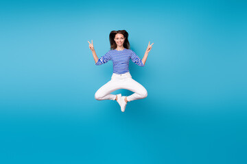 Fototapeta na wymiar Full length body size view of her she nice attractive pretty cheerful cheery funky girl jumping having fun showing double v-sign isolated bright vivid shine vibrant blue color background