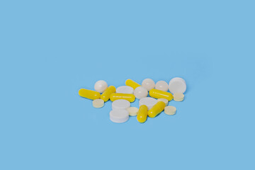 a lot of white and yellow pills on a blue background
