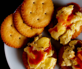 Salty biscutis with topping of cheese ,fluffy eggs and ketchup.