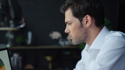 Businessman reading financial reports on laptop screen. Man using laptop