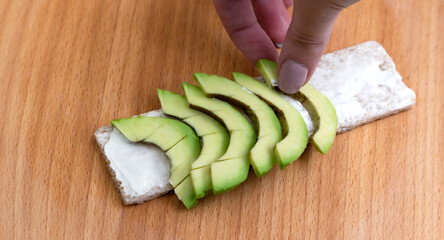 Bread with avocado and spices, toasts on Wooden background.