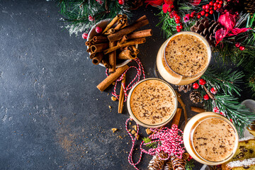 Traditional Christmas egg dairy drink with spices, in different glasses. Eggnog cocktail, Cola de mono, Crème de Vie (Cream of Life) beverage. Dark background with Christmas decor