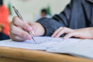 Naklejka premium Woman Hands Student testing in exam on exercise taking at high school or university in test room. Writing document exams at campus classroom, back to school and evaluation measurement in education