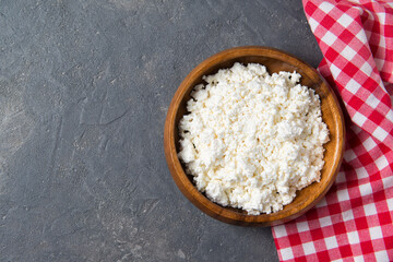 Homemade fresh cottage cheese in a wooden bowl, healthy breakfast concept, top view