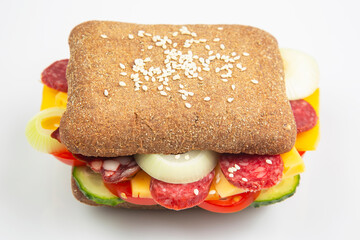 Hamburger with vegetables and sausage on a white background. Fast food and breakfast. Calories and diet.