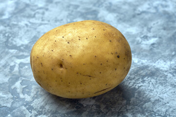 Fresh raw potato on textured background
