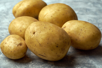 Fresh raw potatoes on textured background