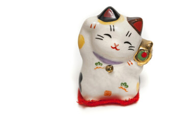 A maneki-neko, lucky cat, beckoning with an upright paw, japanese souvenir isolated