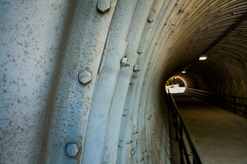 Industrial tunnel with light at end and studs