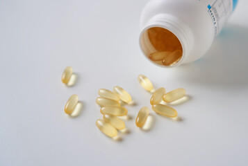 Omega 3 fish oil capsules spilled from a plastic bottle. Medical food supplements. Unsaturated fatty acid.   