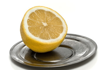 Isolated lemon cut on the metal saucer