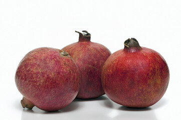 Three ripe pomegranates on isolated white background