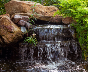 waterfall fountain over rocks in a peaceful garden in Spring, TX.