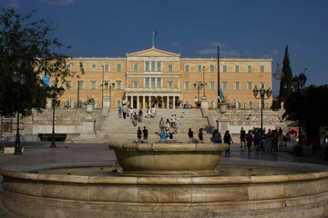 marble fountain in Syntagma Square in Athens, with house of parliament behind