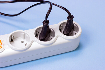 Triple socket white European power adapter with different wires at home. Standard electrical plug...