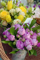 Bouquets of yellow and pink roses in straw basket