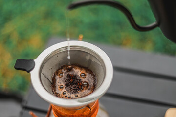 Pouring hot water into a coffee filter In the camping area