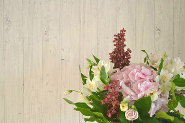Fototapeta na wymiar Beautiful bunch of Peruvian lilies, light pink hydrangea, roses against grey wooden background. Decorative flowers and interior design. 