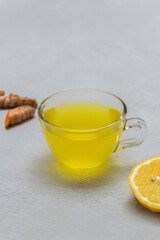 Cup of healing turmeric tea with lemon and ginger