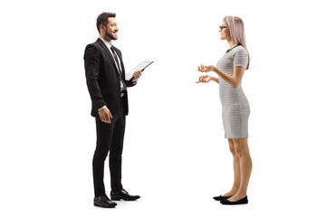 Young woman talking to a man in black suit with cliboard in his hands