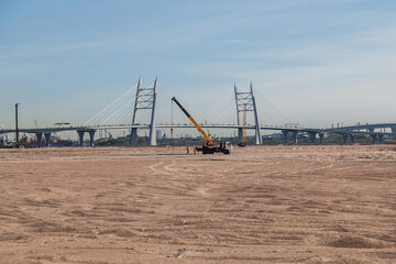 Fototapeta premium Truck crane on pusyoe near the cable-stayed bridge