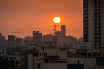 Sun sets behind a high rise skyline of suburban Mumbai