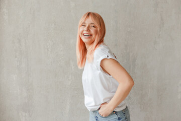 Young joyful woman in white t-shirt with dyed hair laughing