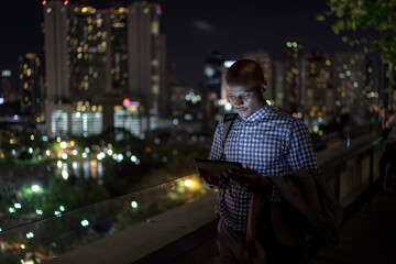 Man using tablet while standing at the balcony
