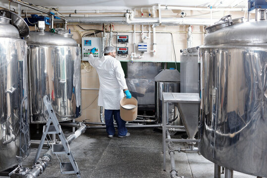 Factory Worker Turning On Churns