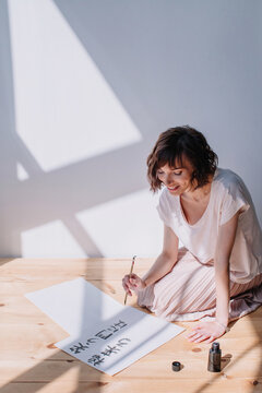 Lovely brunet female practicing calligraphy