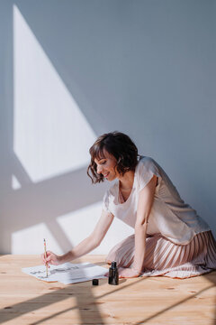 Lovely brunet female practicing calligraphy