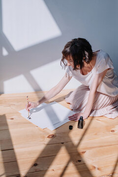 Lovely brunet female practicing calligraphy