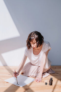 Lovely brunet female practicing calligraphy