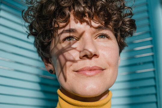 Portrait of young woman with geometrical shadow on face - Powered by Adobe