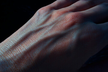 hand with blue blood veins in the dark closeup