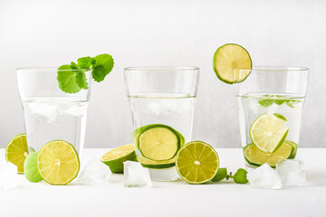 Drink glasses with water ,lime,mint and ice on white background