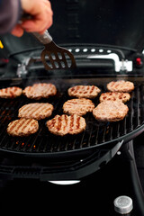 Man grilling steaks on a portable BBQ, Snowy winter barbecue