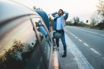 Desperate young man looking for a solution to a broken car