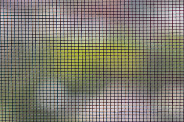 The texture of the mosquito net on the window. Insect protection. The grid is in focus, the...