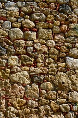 Close up of a wall showing different coloured and sizes of stone