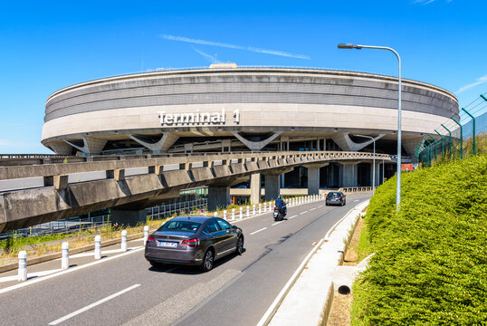 Roissy-en-France, France - July 27, 2020: Passenger cars are reaching the Terminal 1 circular building of Paris-Charles de Gaulle Airport by the access road on a sunny day.