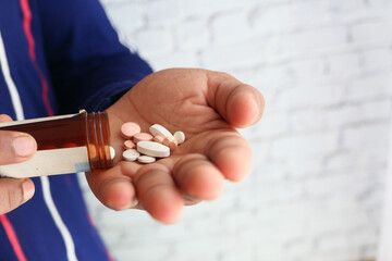 Close up of man hand taking medicine 