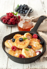 Cottage cheese pancakes with raspberries and blueberries. Tasty breakfast