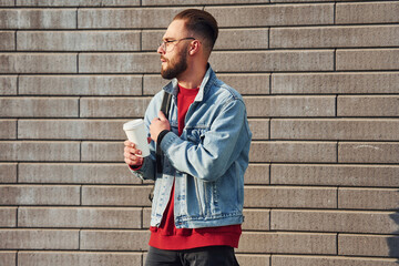 Handsome young guy in casual clothes is outdoors at sunny daytime