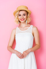 woman in white dress and straw hat on pink