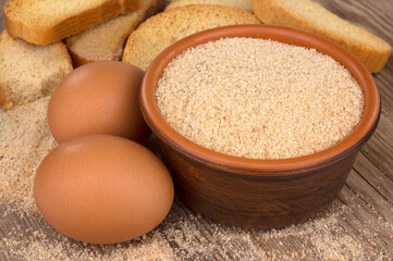 Bowl with breadcrumbs on wooden table